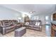 Spacious living room featuring comfortable leather seating, ceiling fan, and natural lighting at 16930 Sweetwater Rd, Dade City, FL 33523