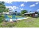 Backyard pool features comfortable blue Adirondack chairs and a lush, green lawn at 16930 Sweetwater Rd, Dade City, FL 33523