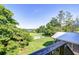 Picturesque view of the in-ground pool and manicured lawn with lake views creating a peaceful outdoor space at 16930 Sweetwater Rd, Dade City, FL 33523