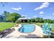 Backyard pool featuring comfortable blue Adirondack chairs, lounge seating, and serene surroundings at 16930 Sweetwater Rd, Dade City, FL 33523
