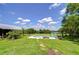 Backyard pool featuring lounge chairs, green lawn, and scenic landscape views at 16930 Sweetwater Rd, Dade City, FL 33523