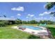 Backyard pool with lounge chairs, a green lawn, and lush landscaping at 16930 Sweetwater Rd, Dade City, FL 33523
