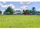 Expansive green property with charming home and red barn under a bright, cloudy sky at 16930 Sweetwater Rd, Dade City, FL 33523