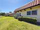 Charming exterior view of attached villas with well-manicured lawn and tropical landscaping at 1701 Pinehurst Rd # 16C, Dunedin, FL 34698