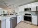 Bright, updated kitchen featuring stainless appliances, white cabinets, granite countertops, and open layout at 1701 Pinehurst Rd # 16C, Dunedin, FL 34698