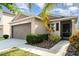 Charming single-story home with a well-manicured lawn, two car garage and inviting entrance at 17334 White Mangrove Dr, Wimauma, FL 33598