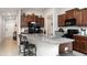 Eat in kitchen with dark wood cabinets, black appliances, and a granite countertop island at 17334 White Mangrove Dr, Wimauma, FL 33598