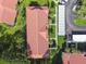 High-angle shot of the red-tiled roof, landscaped walkways, and covered parking at 1801 E Lake Rd # 3A, Palm Harbor, FL 34685