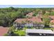 Aerial view of condos with red tile roofs and lush, mature landscaping at 1801 E Lake Rd # 3A, Palm Harbor, FL 34685