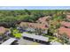 An aerial view showcases the condos with red tile roofs and mature landscape at 1801 E Lake Rd # 3A, Palm Harbor, FL 34685