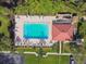 Aerial view of the pool and lounge area with tables and lawn chairs at 1801 E Lake Rd # 3A, Palm Harbor, FL 34685