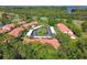 Drone image of the community featuring mature trees, red roofs, convenient parking and nearby roadways at 1801 E Lake Rd # 3A, Palm Harbor, FL 34685