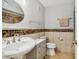 Well-maintained bathroom featuring a sink with storage, a toilet, tile flooring and decorative tile accents at 1801 E Lake Rd # 3A, Palm Harbor, FL 34685