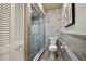 Updated bathroom featuring a modern glass enclosed shower and toilet at 1801 E Lake Rd # 3A, Palm Harbor, FL 34685