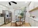 Charming dining area features a glass table, stainless steel refrigerator and bright natural lighting at 1801 E Lake Rd # 3A, Palm Harbor, FL 34685