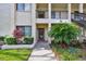 A condo entrance features mature landscaping and a well-lit walkway, creating a welcoming curb appeal at 1801 E Lake Rd # 3A, Palm Harbor, FL 34685