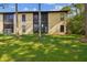 Two-story condo exterior with well-manicured lawn and mature trees creating a peaceful setting at 1801 E Lake Rd # 3A, Palm Harbor, FL 34685