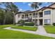 A lush green lawn and mature trees frame this condo building featuring a welcoming entrance and well-kept grounds at 1801 E Lake Rd # 3A, Palm Harbor, FL 34685