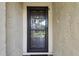 The entryway features a secure screen door and a peephole, complemented by the textured stucco wall at 1801 E Lake Rd # 3A, Palm Harbor, FL 34685