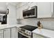 Close-up of a kitchen with stainless steel appliances, white countertops, and a decorative backsplash at 1801 E Lake Rd # 3A, Palm Harbor, FL 34685