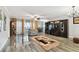 Open living room boasts a TV, built-in shelving, balcony access and stylish rug over glossy wood floors at 1801 E Lake Rd # 3A, Palm Harbor, FL 34685