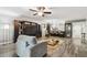 Open-concept living space with hardwood floors, a ceiling fan, and an adjacent kitchen with bar seating at 1801 E Lake Rd # 3A, Palm Harbor, FL 34685