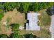 Overhead shot of home's roof and backyard featuring a spacious lawn and mature trees at 2015 Pleasant Acre Dr, Plant City, FL 33566