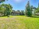 A well-maintained backyard with lush green grass and mature trees, providing a serene outdoor space at 2015 Pleasant Acre Dr, Plant City, FL 33566