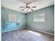 Cheerful bedroom has ceiling fan, two windows, and wood-look tile flooring at 2015 Pleasant Acre Dr, Plant City, FL 33566