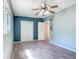 Spacious bedroom has ceiling fan, closet, wood-look tile flooring, and light color scheme at 2015 Pleasant Acre Dr, Plant City, FL 33566