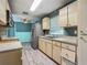 Open kitchen features wood cabinets, tile flooring, and stainless steel refrigerator at 2015 Pleasant Acre Dr, Plant City, FL 33566