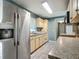 Functional kitchen features stainless steel fridge, wood cabinets, and wood-look tile flooring at 2015 Pleasant Acre Dr, Plant City, FL 33566