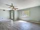 Bright living room featuring neutral walls, modern ceiling fan and stylish gray tile flooring at 2015 Pleasant Acre Dr, Plant City, FL 33566