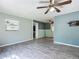 Spacious living room featuring neutral walls, modern ceiling fan and stylish gray tile flooring at 2015 Pleasant Acre Dr, Plant City, FL 33566