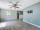 Bright living room featuring neutral walls, modern ceiling fan and stylish gray tile flooring at 2015 Pleasant Acre Dr, Plant City, FL 33566
