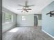 Light-filled living room featuring neutral walls, modern ceiling fan and stylish tile flooring at 2015 Pleasant Acre Dr, Plant City, FL 33566