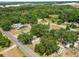 A home viewed from above, surrounded by lush greenery and other homes, complete with adjacent road access at 2504 Jim Johnson Rd, Plant City, FL 33566