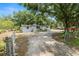 View of exterior of home with dirt driveway and large shade tree in the front yard at 2504 Jim Johnson Rd, Plant City, FL 33566