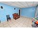 Living room with tile flooring, light blue walls, and a vintage leather sofa at 2504 Jim Johnson Rd, Plant City, FL 33566