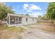 View of the backyard showing a screened in porch with a concrete patio at 3008 W Van Buren Dr, Tampa, FL 33611