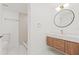 Modern bathroom featuring a sleek vanity, a round mirror, and a glass-enclosed shower at 3008 W Van Buren Dr, Tampa, FL 33611