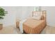 Cozy bedroom with natural light, a woven headboard, a soft comforter and hardwood floors at 3008 W Van Buren Dr, Tampa, FL 33611