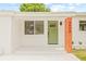 Charming home featuring a white brick exterior, a light green front door, and a wood pillar with black address numbers at 3008 W Van Buren Dr, Tampa, FL 33611