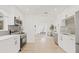 Bright kitchen with stainless steel appliances, white cabinets, gray backsplash, and wood-look flooring at 3008 W Van Buren Dr, Tampa, FL 33611