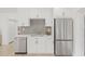 Bright kitchen featuring stainless steel appliances, white cabinets, and a modern backsplash at 3008 W Van Buren Dr, Tampa, FL 33611