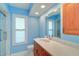 Fresh blue bathroom featuring vanity, window, and glass-enclosed walk-in shower at 3053 Gregor Ct, Palm Harbor, FL 34684