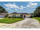 Well-maintained home with lush landscaping and a paved driveway leading to the garage at 3053 Gregor Ct, Palm Harbor, FL 34684