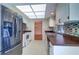 Updated kitchen with stainless steel refrigerator, white cabinetry, and mosaic backsplash at 3053 Gregor Ct, Palm Harbor, FL 34684