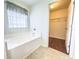 Bathroom featuring a soaking tub, a window, and an open doorway to a spacious walk-in closet at 3095 Coronet Ct, Spring Hill, FL 34609