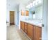 Bathroom with double sinks, wooden cabinets, and a separate shower and walk-in closet at 3095 Coronet Ct, Spring Hill, FL 34609